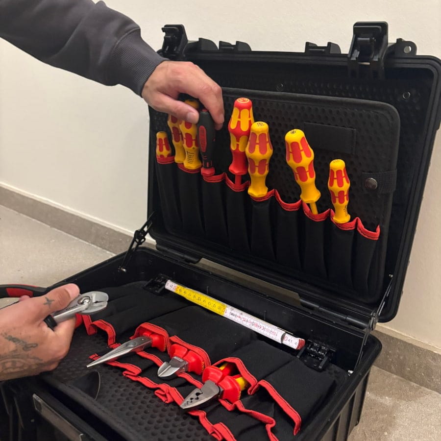 Close-up van de professionele en georganiseerde gereedschapskoffer van elektricien Bouilliart, wat zijn oog voor detail toont.